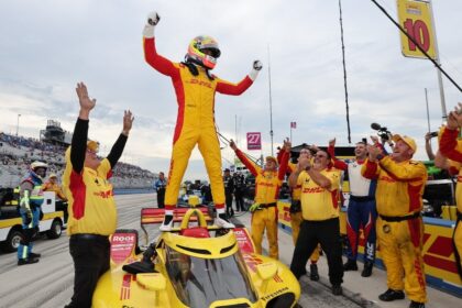 Alex Palou celebra de pie sobre su monoplaza de Chip Ganassi Racing junto a su equipo tras ganar su quinto campeonato de IndyCar.