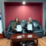 Nazareth Black, CEO de ZACUA, y la Dra. Lulú Medina Ortega, presidenta de CANACINTRA, sosteniendo el convenio de colaboración firmados en una oficina corporativa.