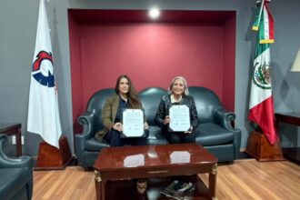 Nazareth Black, CEO de ZACUA, y la Dra. Lulú Medina Ortega, presidenta de CANACINTRA, sosteniendo el convenio de colaboración firmados en una oficina corporativa.