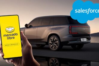 Mano sosteniendo un smartphone con la aplicación de Mercado Libre Negocios frente a una SUV GAC GS7 gris con la nube de Salesforce de fondo.