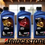 Tres envases de lubricantes para motor de la marca ELF junto al logotipo de Bridgestone sobre una mesa de madera.