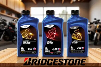 Tres envases de lubricantes para motor de la marca ELF junto al logotipo de Bridgestone sobre una mesa de madera.