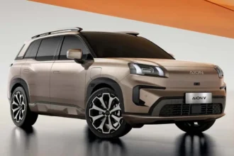 Vista frontal de la SUV eléctrica GAC AION V en color beige con detalles oscuros, exhibida en estudio.