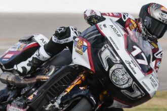 Piloto de carreras sobre una motocicleta bagger Indian Challenger RR con el número 17 inclinándose en una curva de pista.