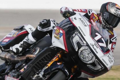 Piloto de carreras sobre una motocicleta bagger Indian Challenger RR con el número 17 inclinándose en una curva de pista.