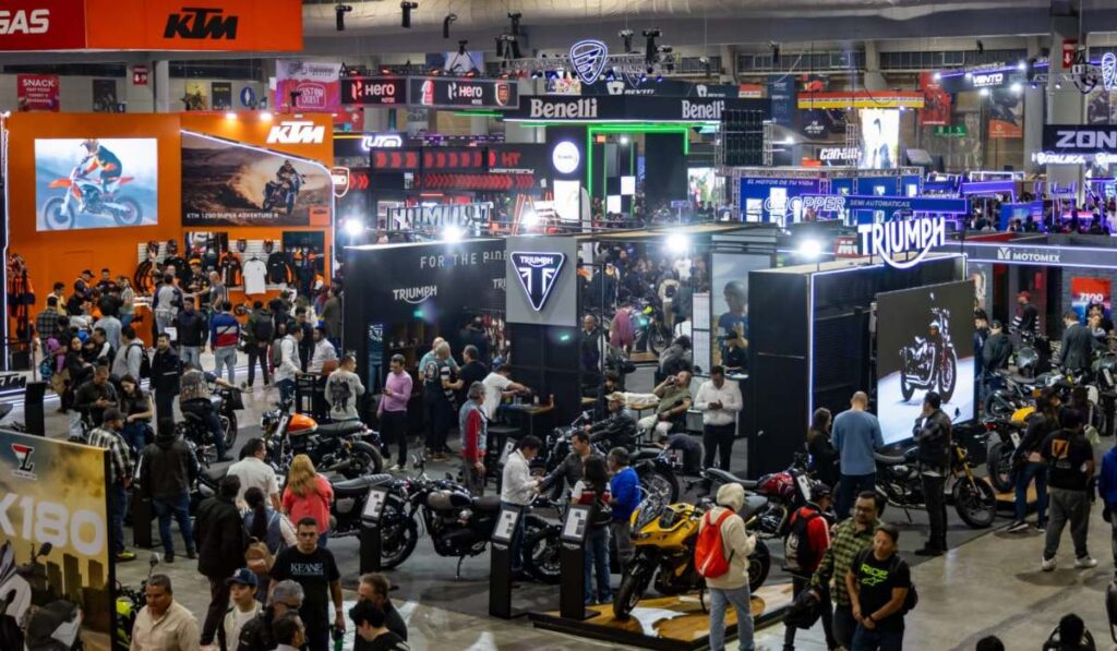 Vista panorámica del piso de exhibición del Salón Internacional de la Motocicleta México (SIMM) 2026 en Expo Santa Fe repleto de asistentes y stands de marcas.