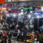 Vista panorámica del piso de exhibición del Salón Internacional de la Motocicleta México (SIMM) 2026 en Expo Santa Fe repleto de asistentes y stands de marcas.