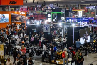 Vista panorámica del piso de exhibición del Salón Internacional de la Motocicleta México (SIMM) 2026 en Expo Santa Fe repleto de asistentes y stands de marcas.