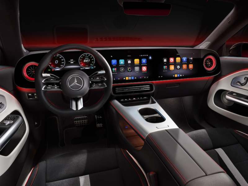 Cabina del nuevo Mercedes-Benz CLA con pantalla digital MBUX Hyperscreen, volante multifunción e iluminación ambiental roja.