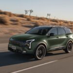 SUV Kia Sportage 2027 color verde en movimiento sobre una carretera desértica.