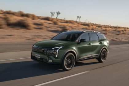 SUV Kia Sportage 2027 color verde en movimiento sobre una carretera desértica.