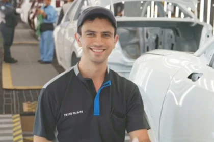 Luis Segoviano, inspector de calidad con discapacidad auditiva en la planta de Nissan Aguascalientes A1, sonriendo en la línea de producción.
