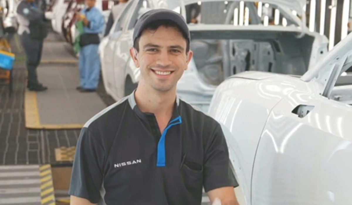 Luis Segoviano, inspector de calidad con discapacidad auditiva en la planta de Nissan Aguascalientes A1, sonriendo en la línea de producción.