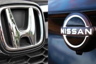 Emblemas cromados e iluminados de Honda y Nissan presentados frente a frente para ilustrar su alianza en vehículos definidos por software.