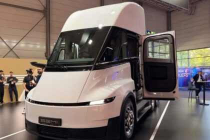 Vista frontal del camión eléctrico Tesla Semi color blanco con la puerta del conductor abierta en el centro de convenciones de IAA Transportation 2026.