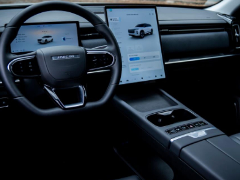 Interior minimalista de la SUV JAECOO 7 destacando el volante multifunción forrado en piel, el cuadro de instrumentos digital y la pantalla central.