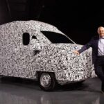 Ejecutivo apoyado sobre una van de carga camuflada durante la presentación de la alianza entre Volkswagen Camiones y Buses y SAIC Motor.