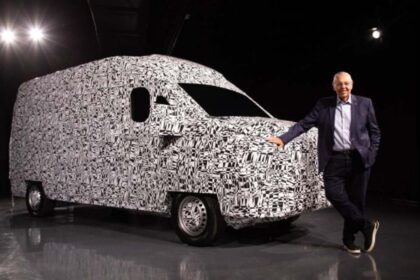 Ejecutivo apoyado sobre una van de carga camuflada durante la presentación de la alianza entre Volkswagen Camiones y Buses y SAIC Motor.