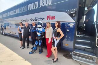 Rafael Kisel, Benjamín Galván y Virginia Olalde posando junto al nuevo autobús Volvo 9800 de Ómnibus de México y un bot caracterizado en la planta de Tultitlán.