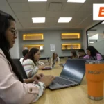 Equipo de trabajo de BitCar en sus oficinas corporativas colaborando en computadoras para promover el modelo de usership automotriz.
