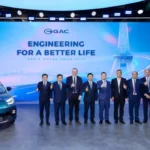 Ejecutivos de GAC Group posando junto al nuevo AION UT Cross durante su presentación mundial en el Salón del Automóvil de París 2026.