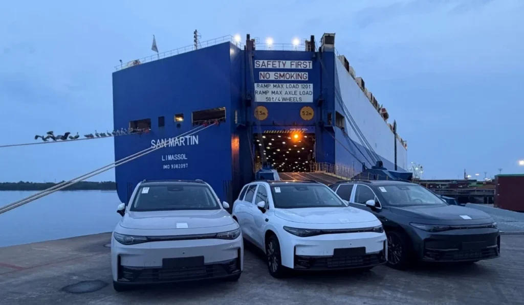 Modelos Leapmotor C10 y C16 desembarcando en puerto de México frente a un buque de carga marítima.