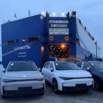 Modelos Leapmotor C10 y C16 desembarcando en puerto de México frente a un buque de carga marítima.