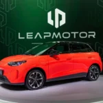Hatchback eléctrico Leapmotor B03 en color naranja exhibido sobre plataforma giratoria durante el Salón del Automóvil de París 2026.