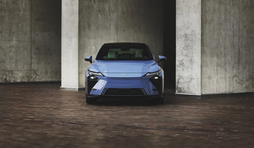 Vista frontal del nuevo sedán híbrido Lexus ES 350h en color azul enmarcado por columnas de concreto arquitectónico.