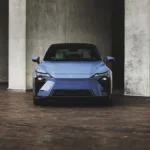 Vista frontal del nuevo sedán híbrido Lexus ES 350h en color azul enmarcado por columnas de concreto arquitectónico.