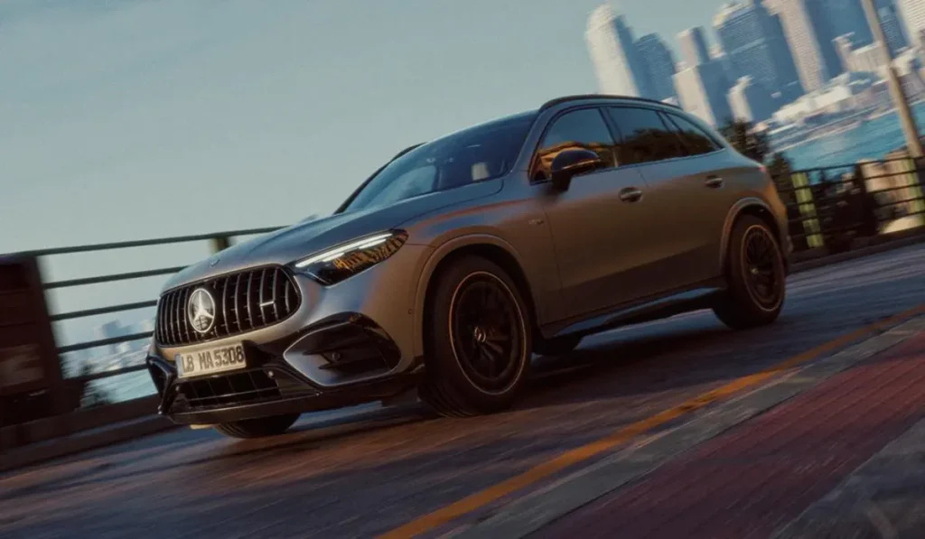 Mercedes-AMG GLC 53 4MATIC+ en color gris grafito circulando por una carretera costera con rines de 21 pulgadas.