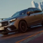 Mercedes-AMG GLC 53 4MATIC+ en color gris grafito circulando por una carretera costera con rines de 21 pulgadas.