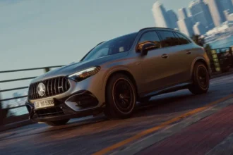 Mercedes-AMG GLC 53 4MATIC+ en color gris grafito circulando por una carretera costera con rines de 21 pulgadas.