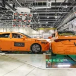 Dos vehículos Mercedes-Benz CLA de prueba color naranja en el momento exacto del impacto lateral durante la prueba de choque a alta velocidad.