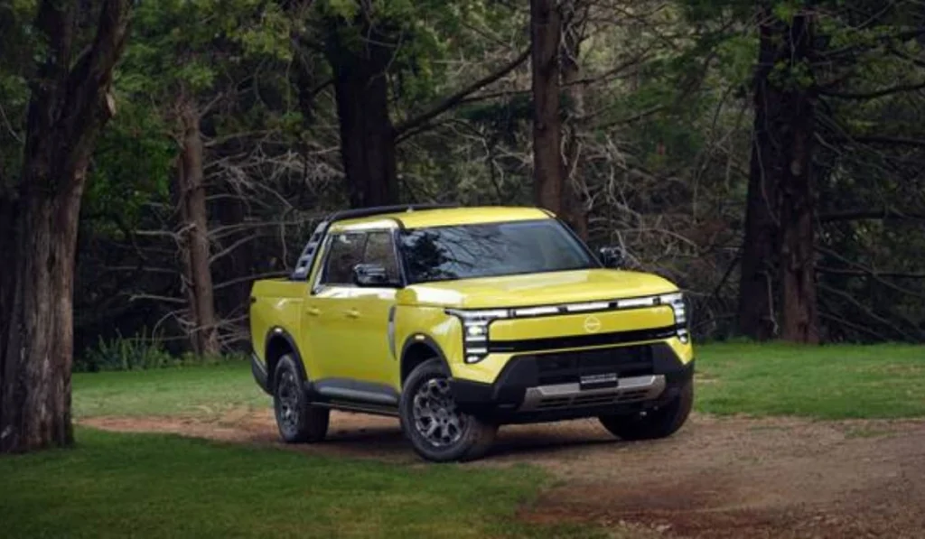 Pickup Nissan Frontier PRO PHEV color amarillo verdoso estacionada en un camino boscoso mostrando su diseño frontal Ruggedtech.