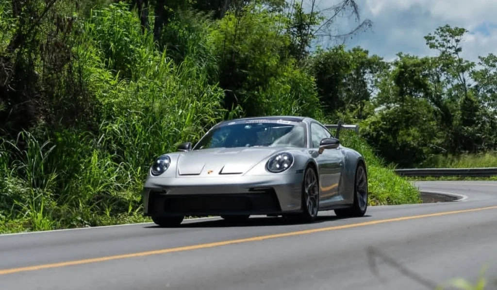 Automóvil deportivo Porsche circulando por una carretera pavimentada rodeada de vegetación durante el Rally de las Haciendas 2026.