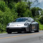 Automóvil deportivo Porsche circulando por una carretera pavimentada rodeada de vegetación durante el Rally de las Haciendas 2026.