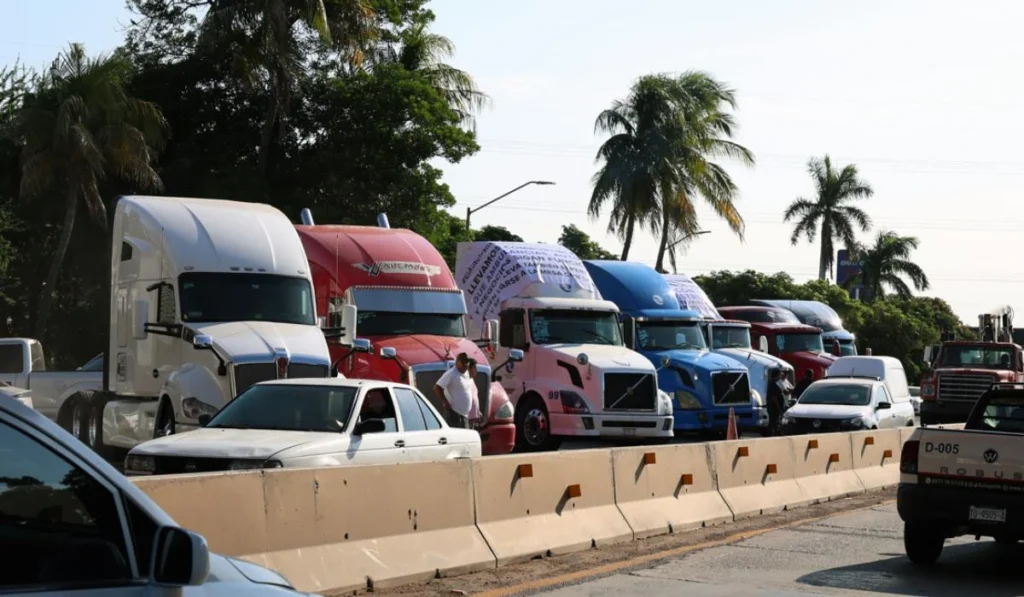 Fila de camiones de carga y tráileres detenidos a un costado de la carretera en señal de protesta por la Reforma Fiscal y el estímulo de casetas.