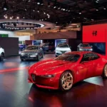Stand de exposición automotriz con vehículos Alfa Romeo destacando un modelo deportivo rojo en primer plano durante un evento de la industria.
