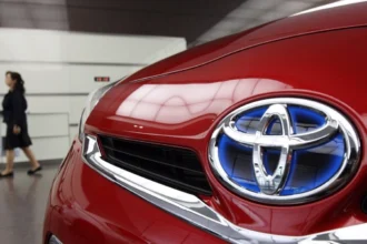 Logotipo y parrilla frontal de un vehículo híbrido de Toyota de México con el emblema característico en tono azul.