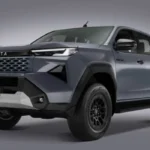 Vista tres cuartos frontal de la nueva pickup Toyota Hilux 2027 en color gris con parrilla y fascia renovadas.